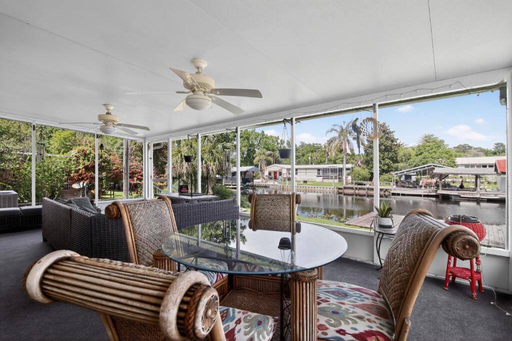 a dining room with a table and chairs and windows at Boat Dock! 'Sunshine House' on St. Johns River in Astor