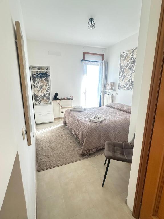 a bedroom with a bed and a chair and a window at La tenuta di Greta in Canino