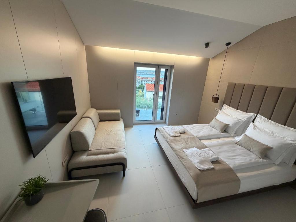 a bedroom with a bed and a couch and a tv at Vista on the sea in Ankaran