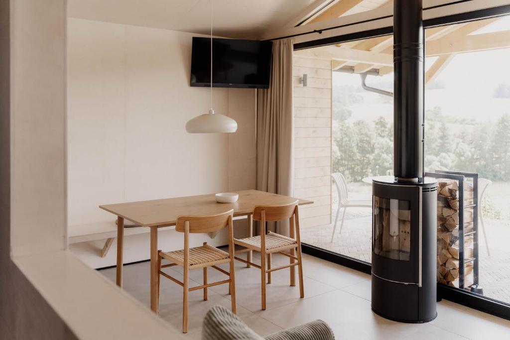 a dining room with a table and a fireplace at Hüttenchalets Rhön in Geisa