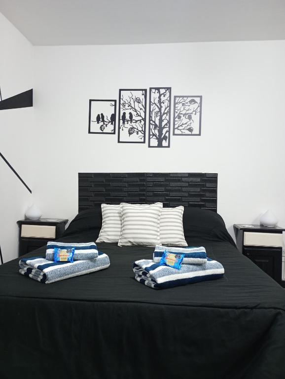 ein Schlafzimmer mit einem schwarzen Bett und drei Kissen darauf in der Unterkunft Suite Munro in Munro