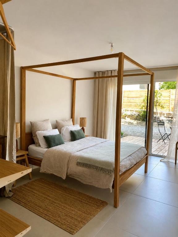 a bedroom with a canopy bed and a patio at Chambre cosy in Viols en Laval