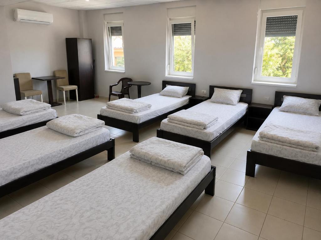 a room with four beds in a room with windows at Apartman za 6 osoba BOR in Bor