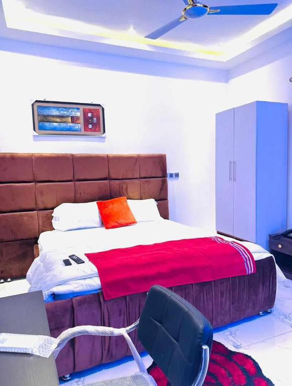 a bedroom with a bed and a desk and a chair at MyTime Hotel in Tamale