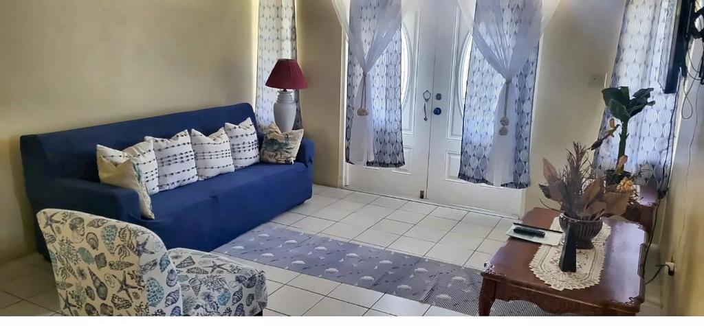a living room with a blue couch and a table at Sailor's Gem in Tortola Island
