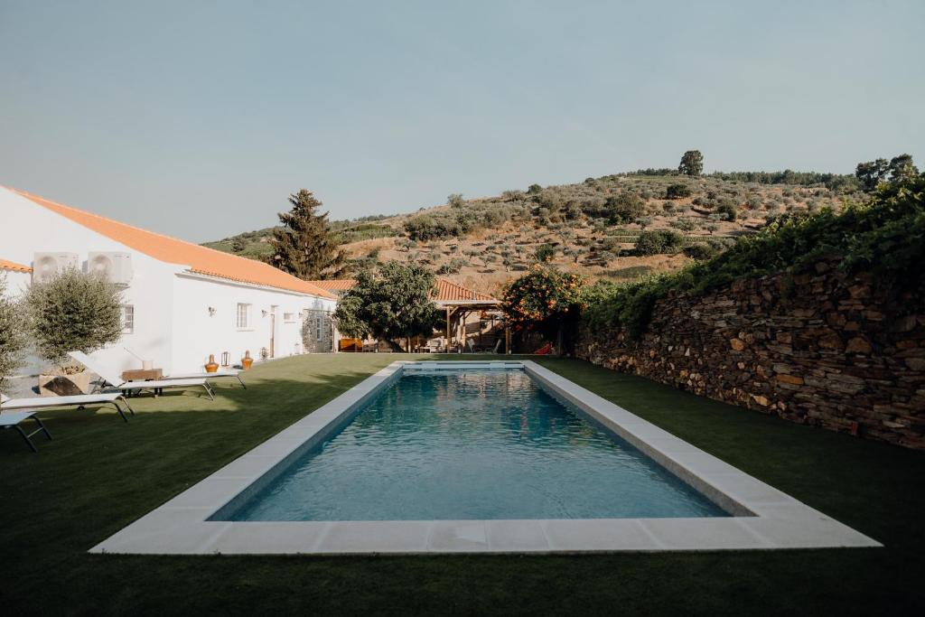 a swimming pool in a yard next to a house at Valadouro Dona Adelaïde With a Pool in Espinhosa