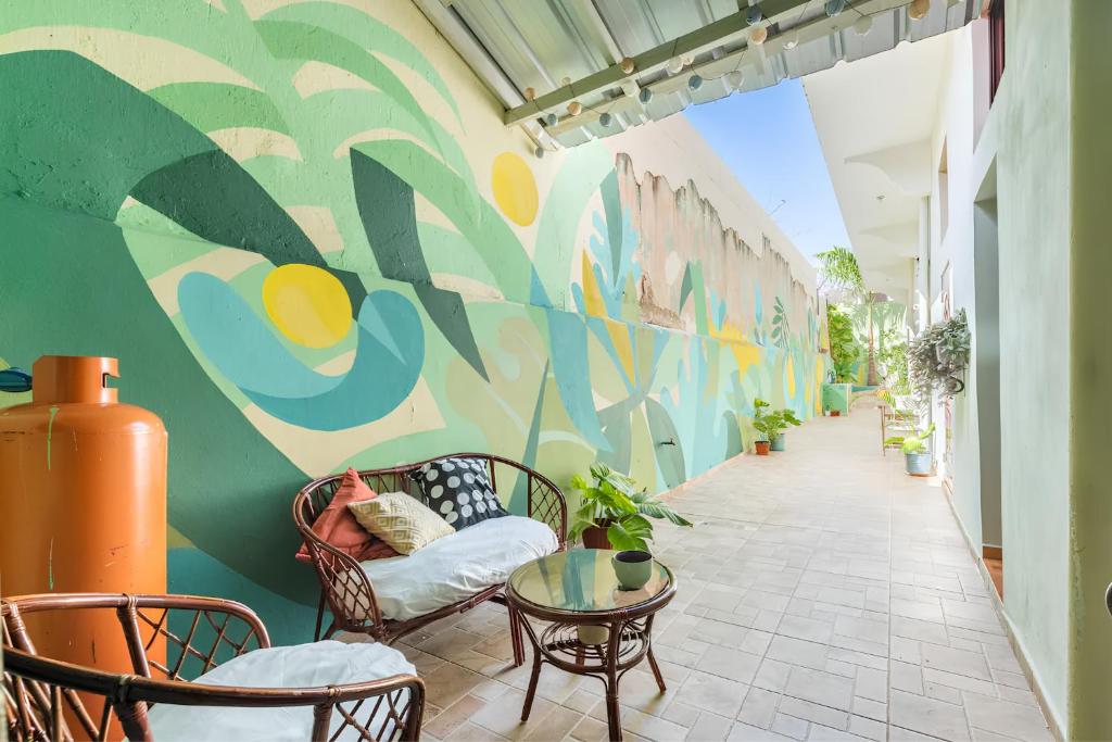 a hallway with chairs and a table and a mural at Casa Donderis in Santo Domingo
