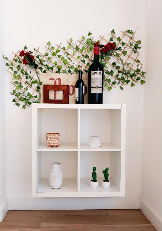 a shelf with two bottles of wine and flowers at Beach Veranda Hotel Punta Cana in Punta Cana