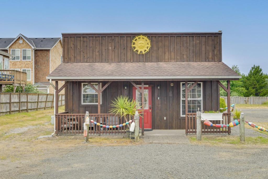 a small building with a red door and a clock at Cute Studio Cabin Steps to Long Beach Boardwalk in Long Beach
