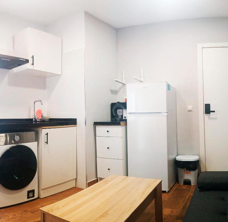 a small kitchen with a refrigerator and a table at Apartamento El Centro in Algarrobo