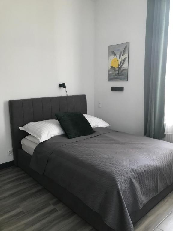 a bedroom with a large bed with white pillows at Willa Pod Platanem in Bytów