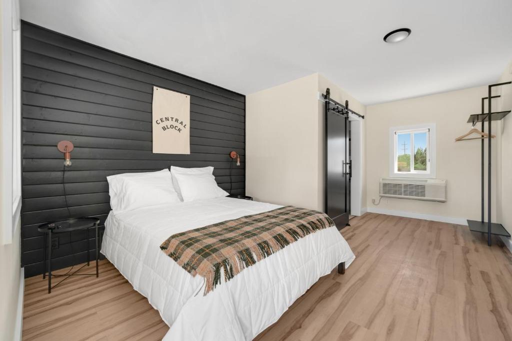 a bedroom with a large bed with a black headboard at The Central Block Bend Motel in Bend