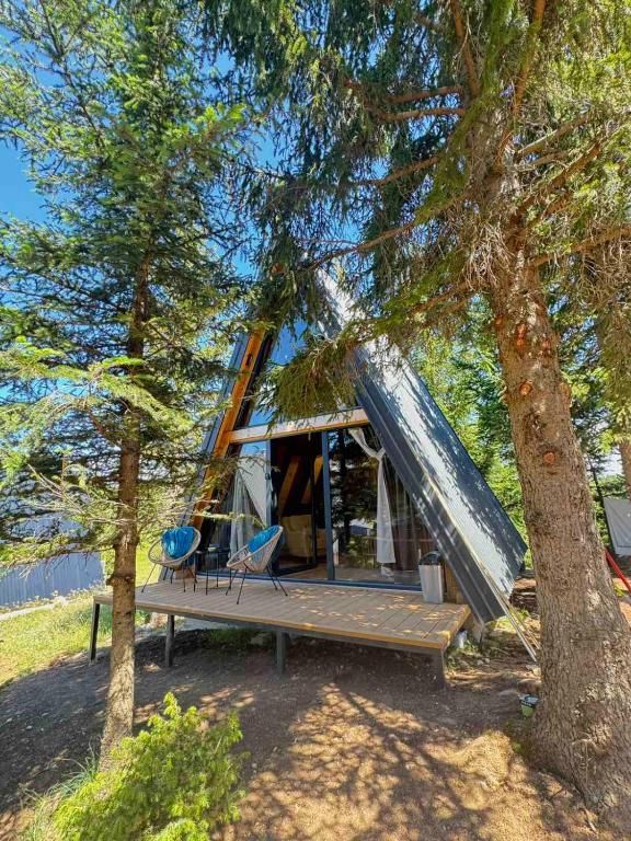 a cabin in a tree with a tent at Forest Whisper Lux - A-frame cabin with private hot tub in Kovačka Dolina