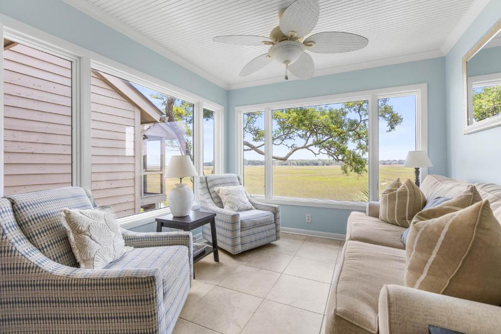 a living room with two chairs and a ceiling fan at 1211 Creekwatch Villa in Seabrook Island