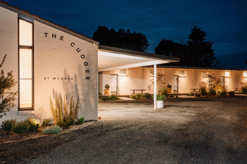 a building with a sign that reads the coop at night at The Cudgee at Mudgee in Mudgee
