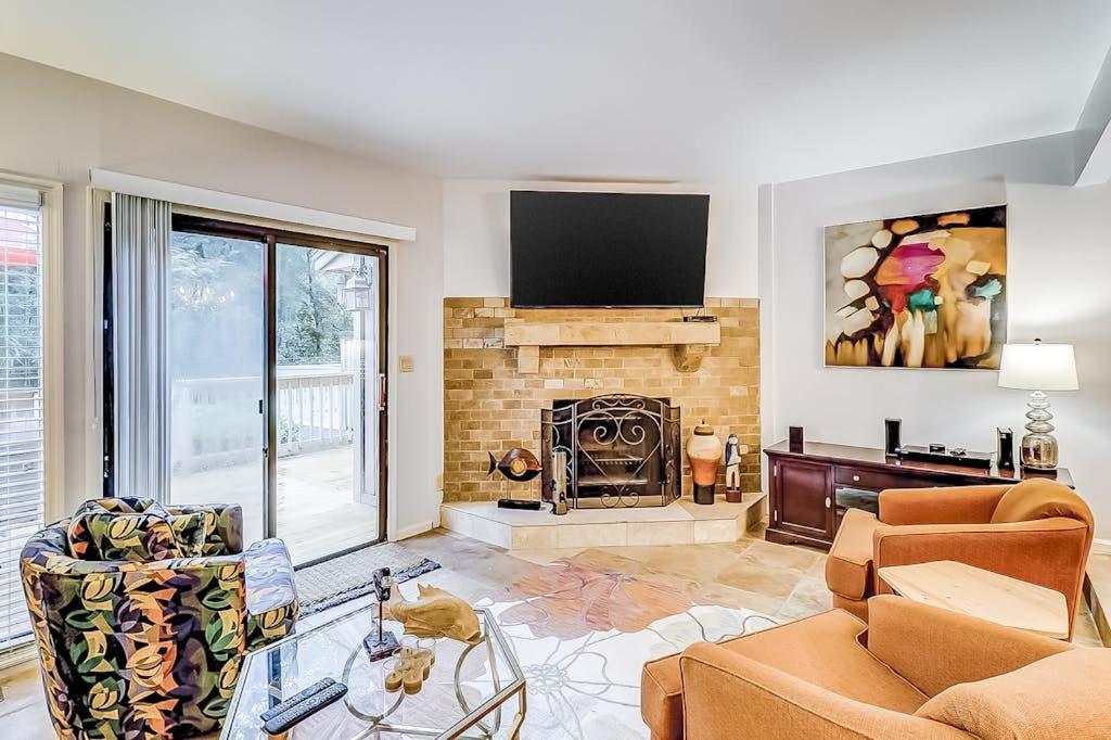 a living room with a fireplace and a tv at Beachwalk 124 in Hilton Head Island