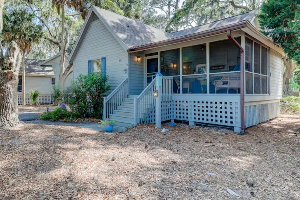 a small blue house with a porch and a porch at Firefly Cottage in Edisto Beach