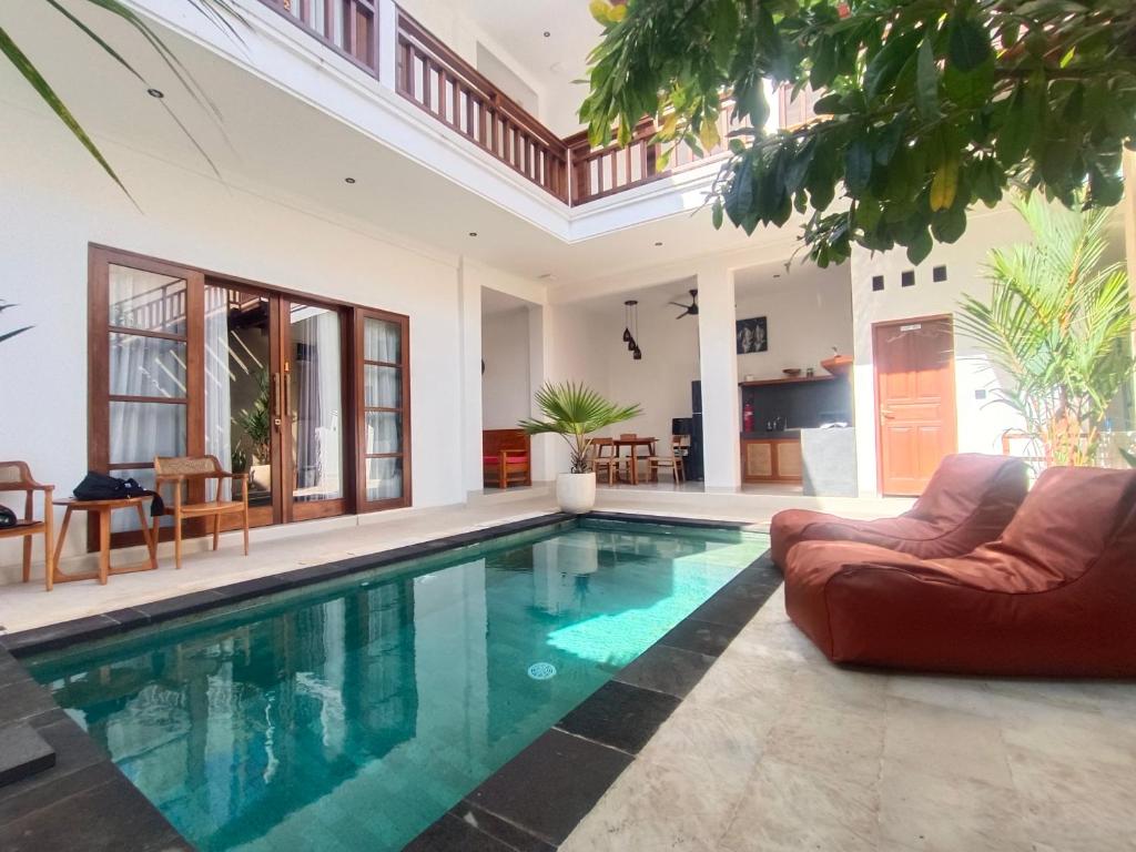 a swimming pool in a house with a living room at Artha Sadia Villa 1 Seseh Beach in Cemagi