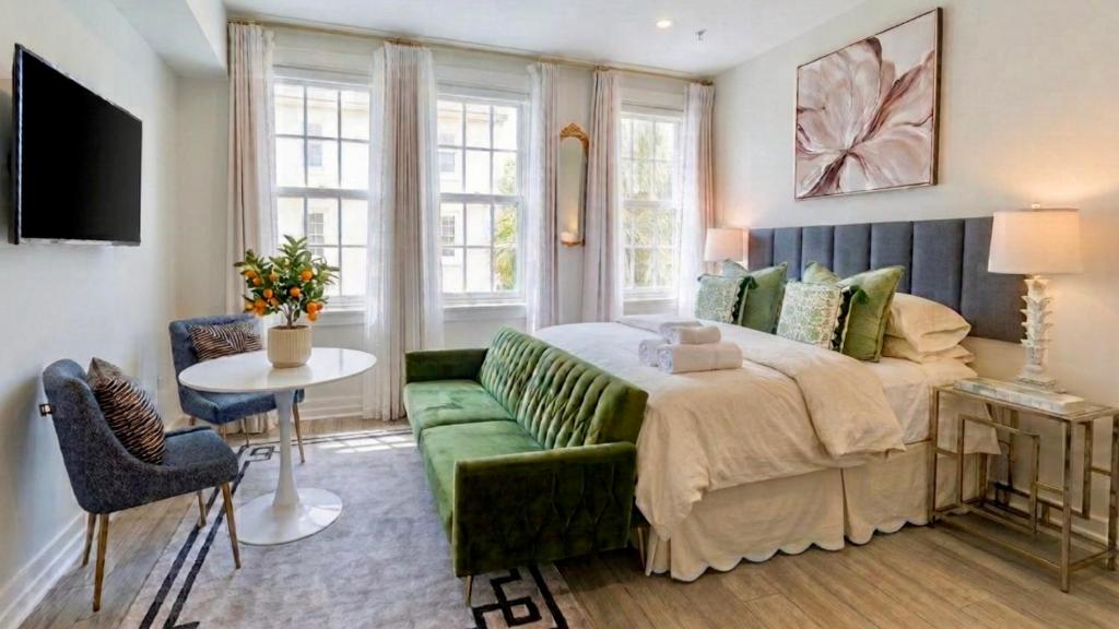 a bedroom with a bed and a green couch at The Green Room - Pool View with Parking Spot at 1920s Historic Residence with 24x7 Reception Desk on Palm Beach Island in Palm Beach