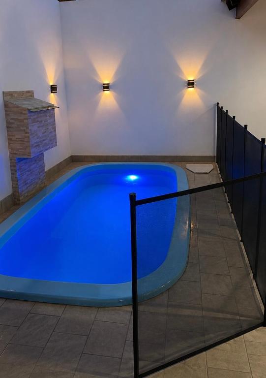 a large blue pool in a room with a fireplace at Recanto Peixoto in Olímpia
