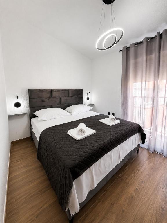 a bedroom with a large bed with two towels on it at Apartments & Rooms Prižmić in Podstrana
