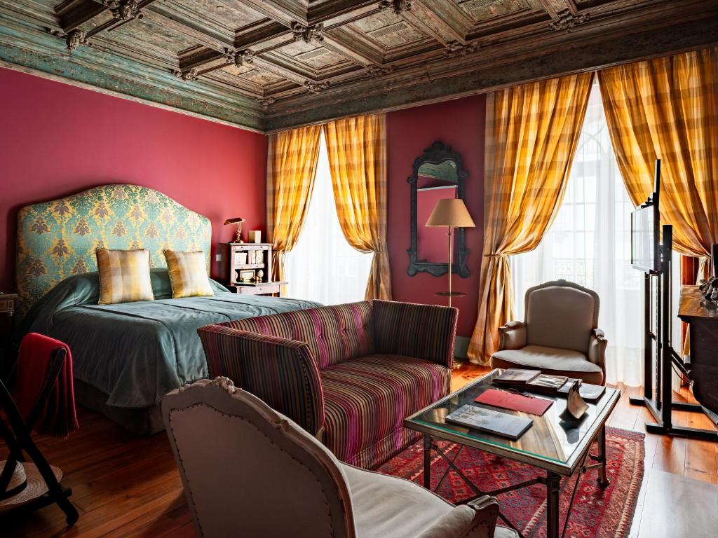 a bedroom with a bed and a couch and a table at M Maison Particulière Porto in Porto