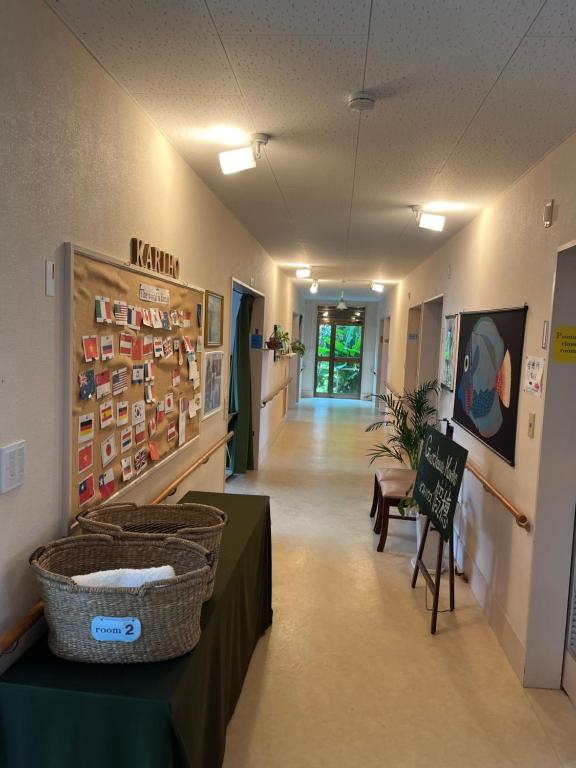 a hallway of a hospital with a table with baskets on it at ゲストハウス假穂 in Yoron