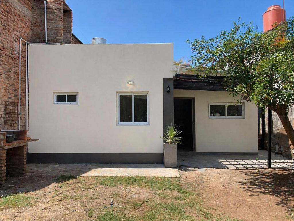 a white facade of a house with a tree at Alojamiento LowCost San Rafael in San Rafael