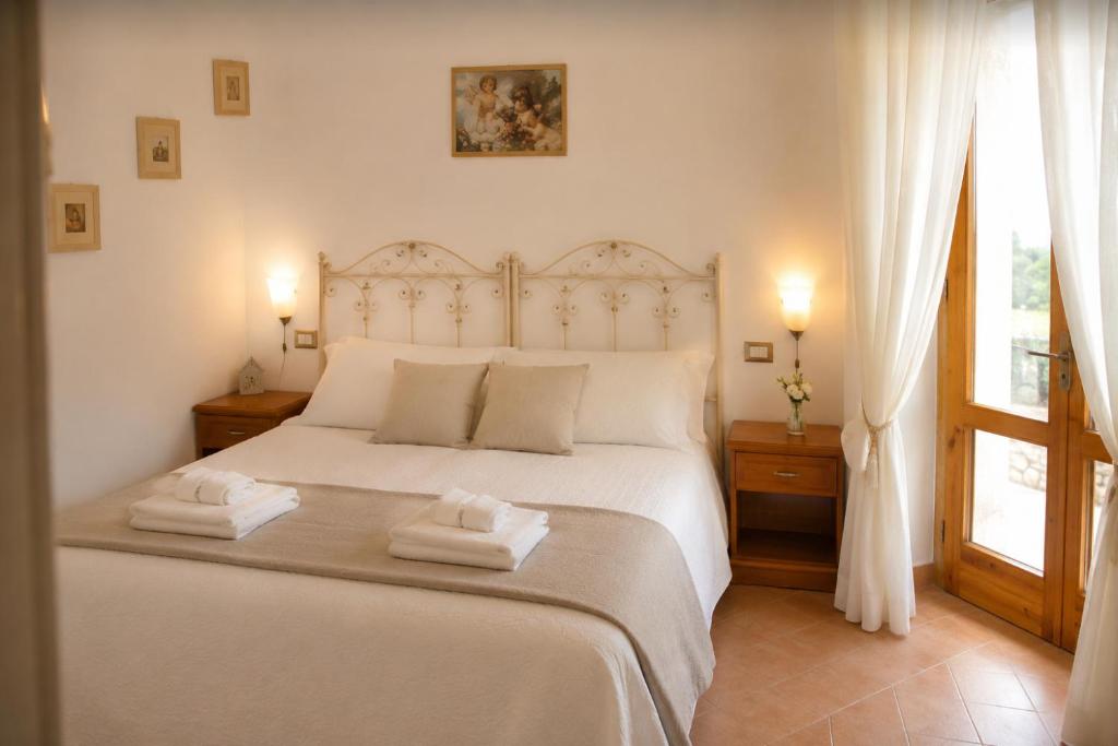 a bedroom with a white bed with two towels on it at Villa Olimpo B&B in Fasano