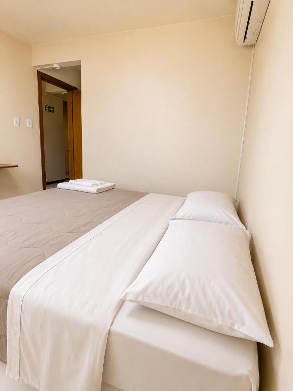 a bedroom with two beds with white sheets at hotel Maanaim in Candói