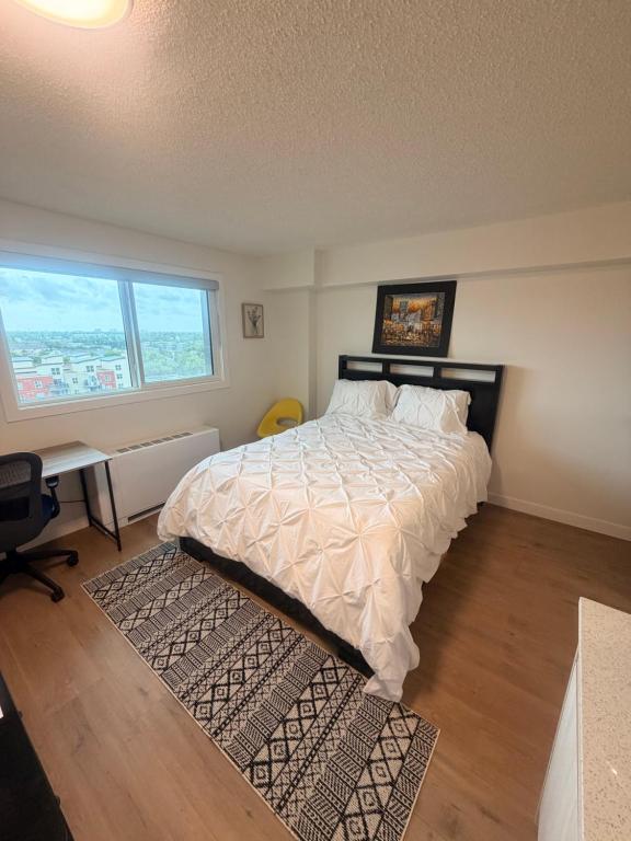 a bedroom with a bed with a desk and a window at Urban Nest in Edmonton