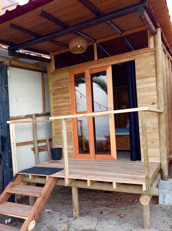 a wooden house with a porch and windows at Palmarío Beach House in Guachaca