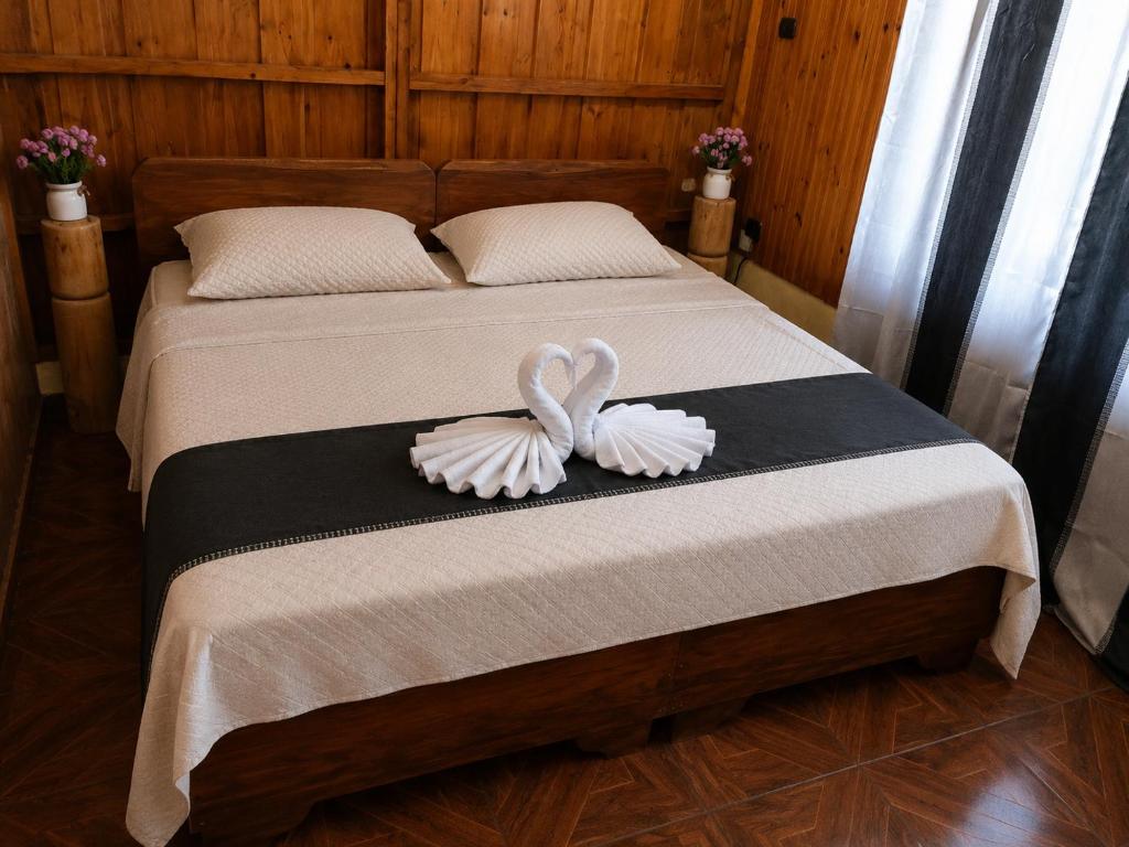 a bed with a white bow on top of it at Maye WOOD APT in Uvita