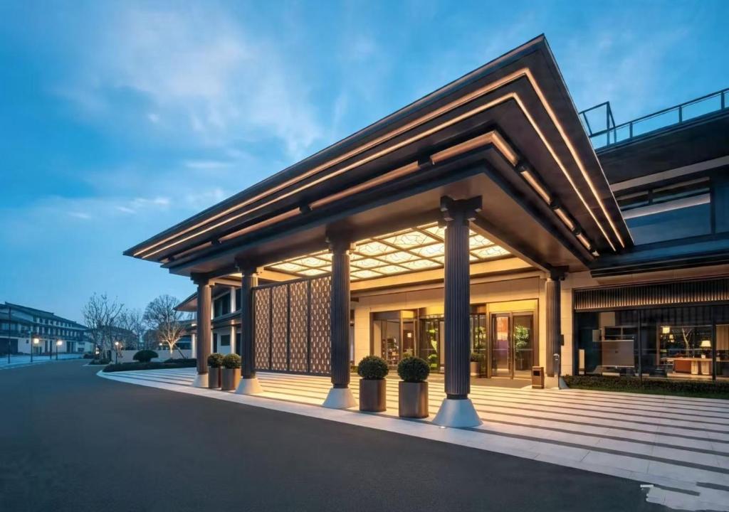 a building with a porch with potted plants on it at Bristoria Hotel Yangzhou in Yangzhou