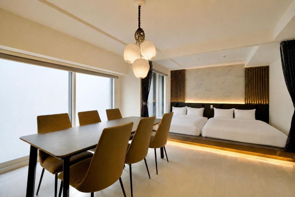 a dining room with a bed and a table and chairs at Grand Success Kotoni ll in Sapporo