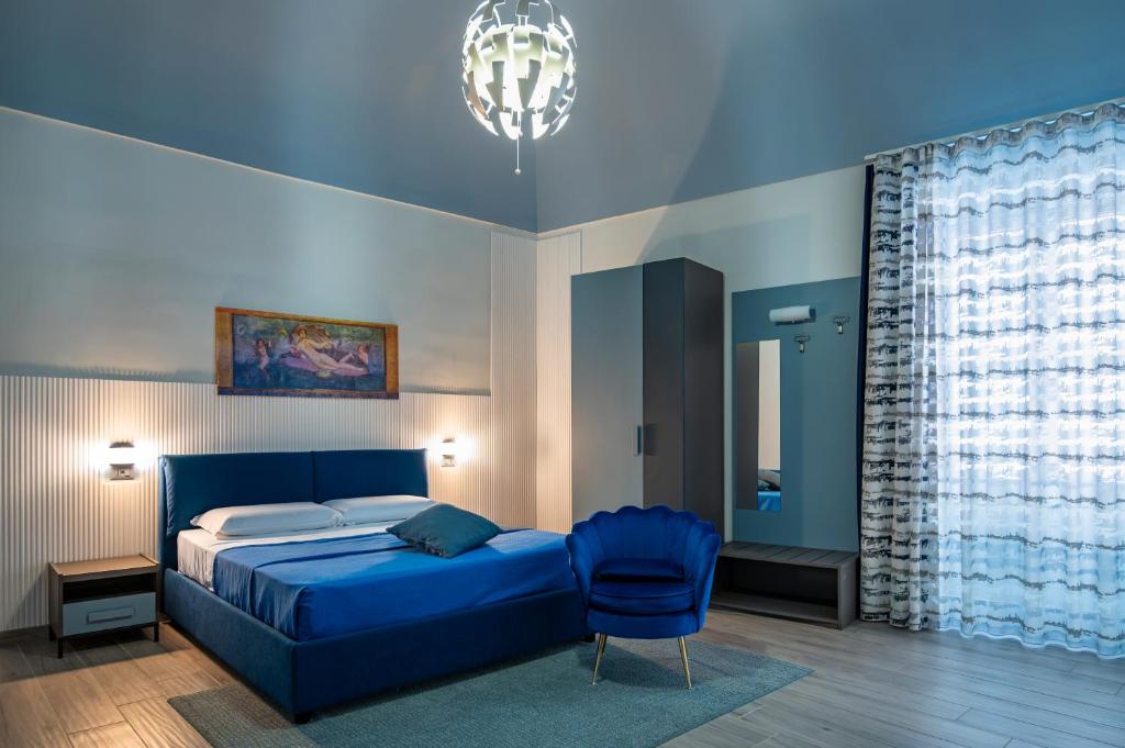 a bedroom with a blue bed and a blue chair at Domus Alma Pompei in Pompei