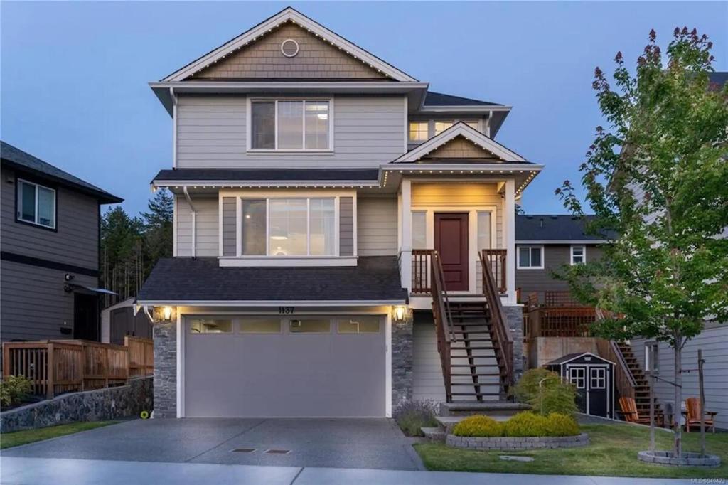 a large house with a white garage door at Spacious Private Suite Minutes Away from Ocean,Trails and Stores in Langford