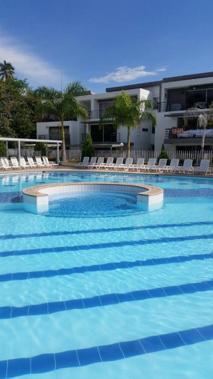 a large swimming pool with chairs and a building at Oasis Santafe in Santa Fe de Antioquia