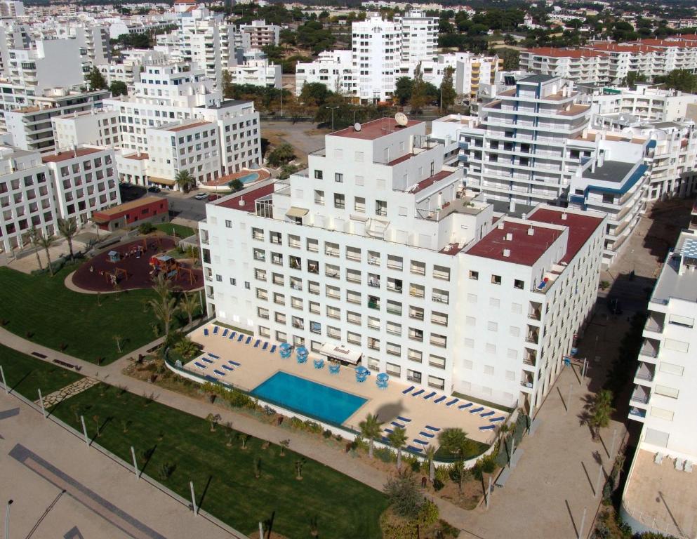 an aerial view of a large white building with a pool at Apartamentos Carteia in Quarteira