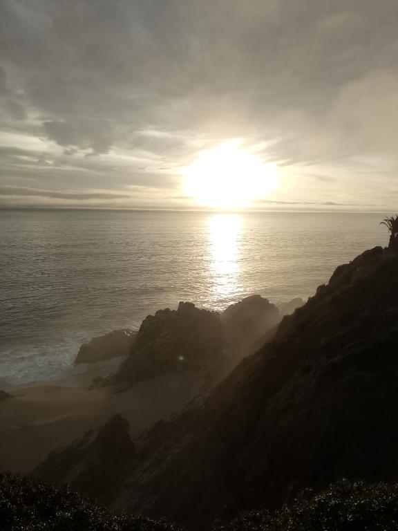a sunset over the ocean with the sun on the horizon at Cabañas mirasol in Algarrobo