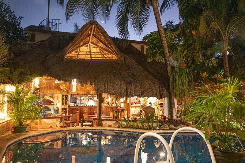 a resort with a swimming pool and a resort with a restaurant at Cocos Cabañas Playa del Carmen Adults Only in Playa del Carmen