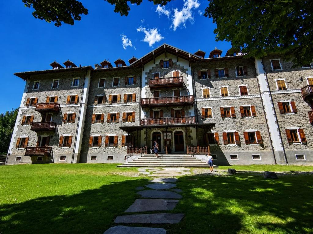 a large building with people standing outside of it at Attic historic building with air conditioning in Ceresole Reale