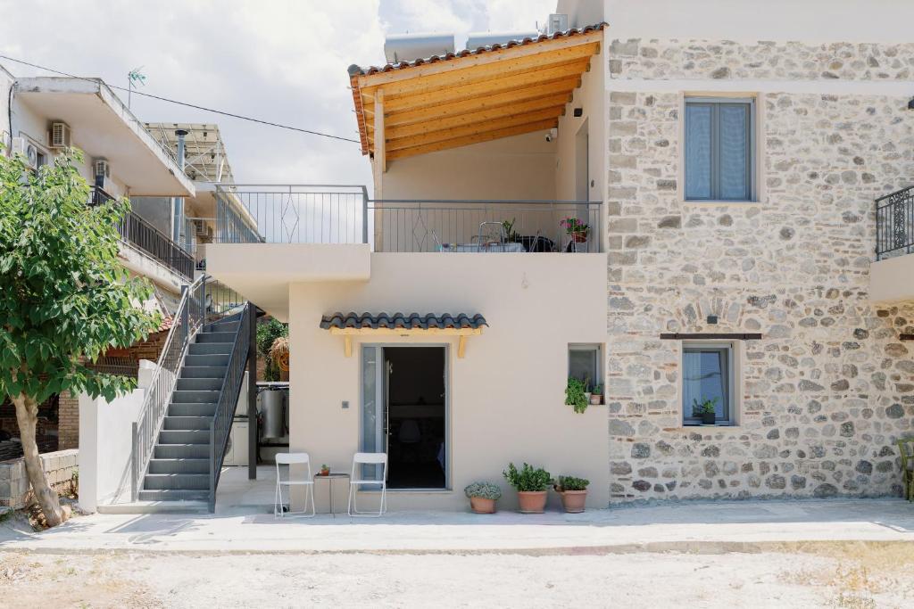 a house with a staircase in front of it at Lithos Blue Agios Vasilios in Áyios Vasílios