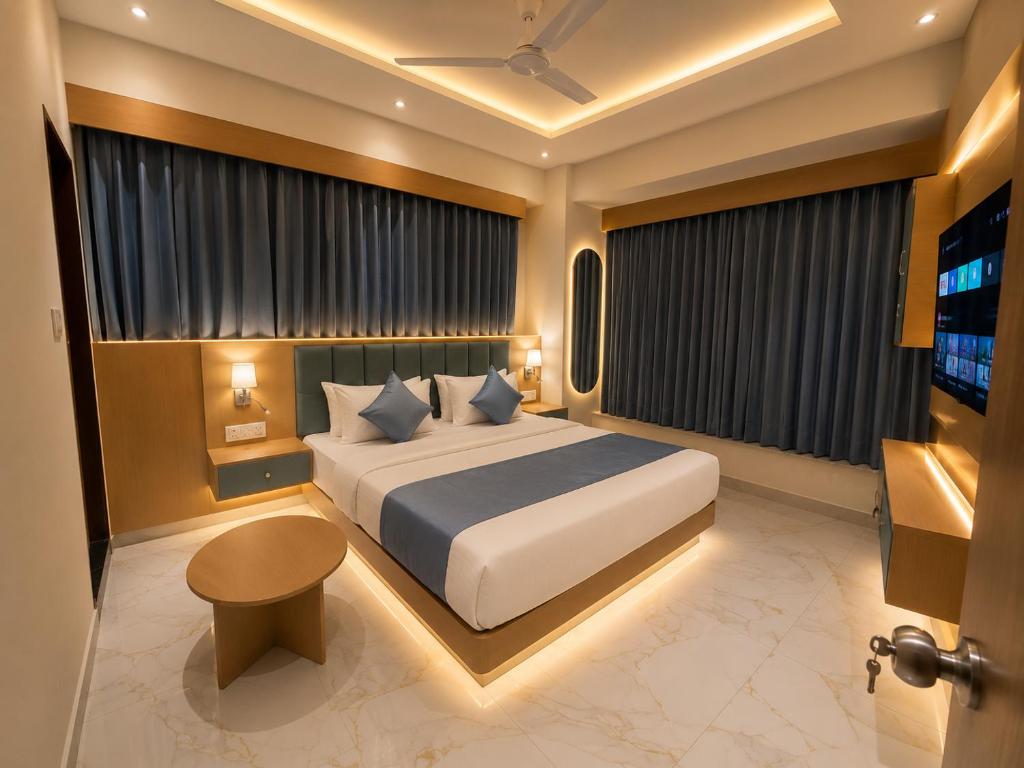 a bedroom with a large white bed and a television at Hotel VAAYU Stay IGI Airport in New Delhi