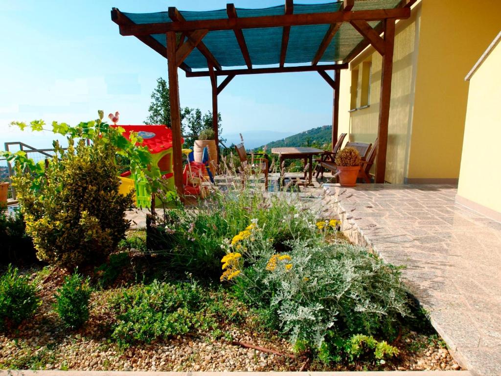 a garden on a house with a wooden pergola at Apartments Jakov in Matulji