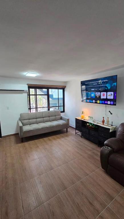 a living room with a couch and a flat screen tv at Las Minervas in Monterrey