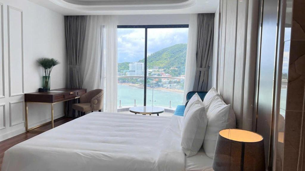 a hotel room with a bed and a large window at Khác Sạn Oytes Bay in Xa Thang Nhi