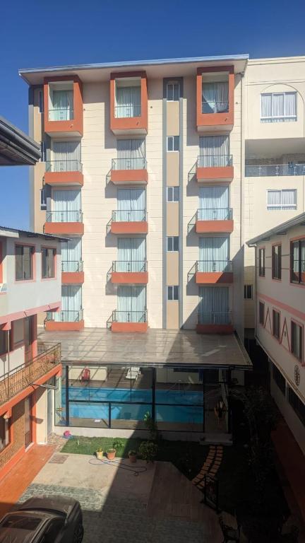 a building with a swimming pool in front of it at Hotel Central in Cochabamba