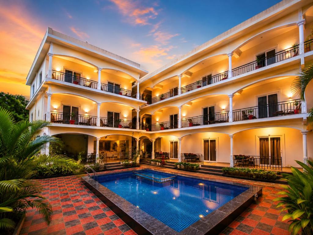 an exterior view of a building with a swimming pool at Morjim Sunset Hotel in Morjim
