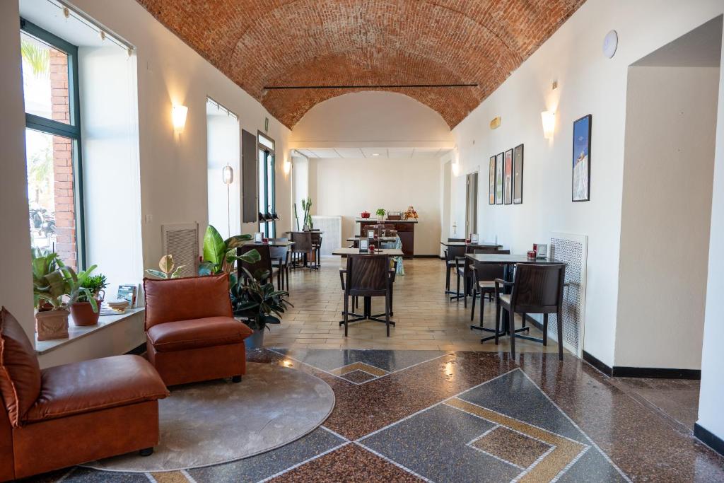 a lobby with chairs and tables in a building at Hotel Miramare in Pietra Ligure